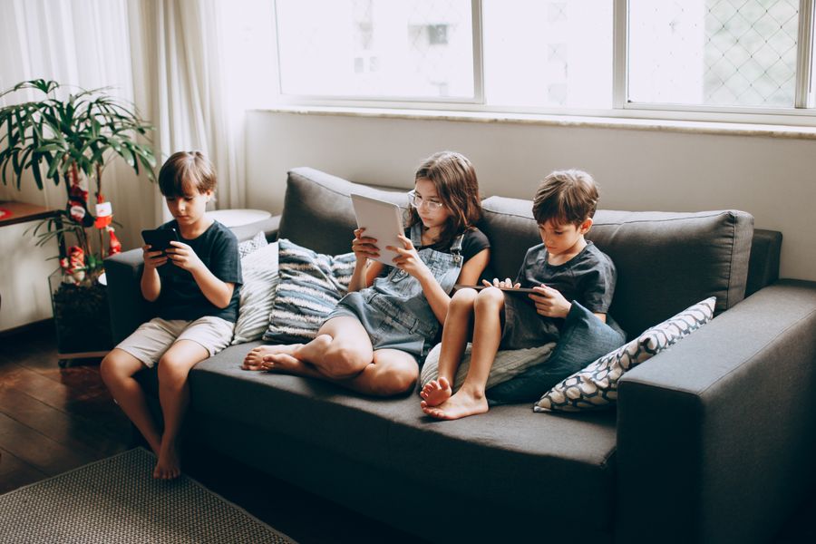 Niños con dispositivos digitales en hogar conectado